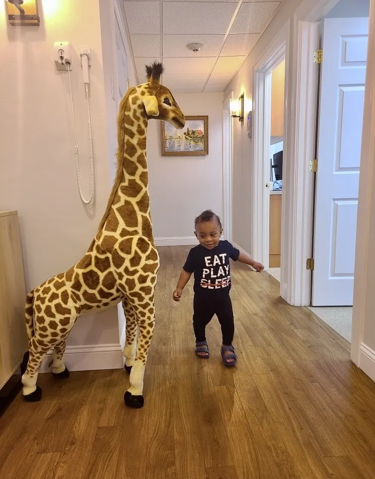 A young patient walking down the office hallway past the giant giraffe