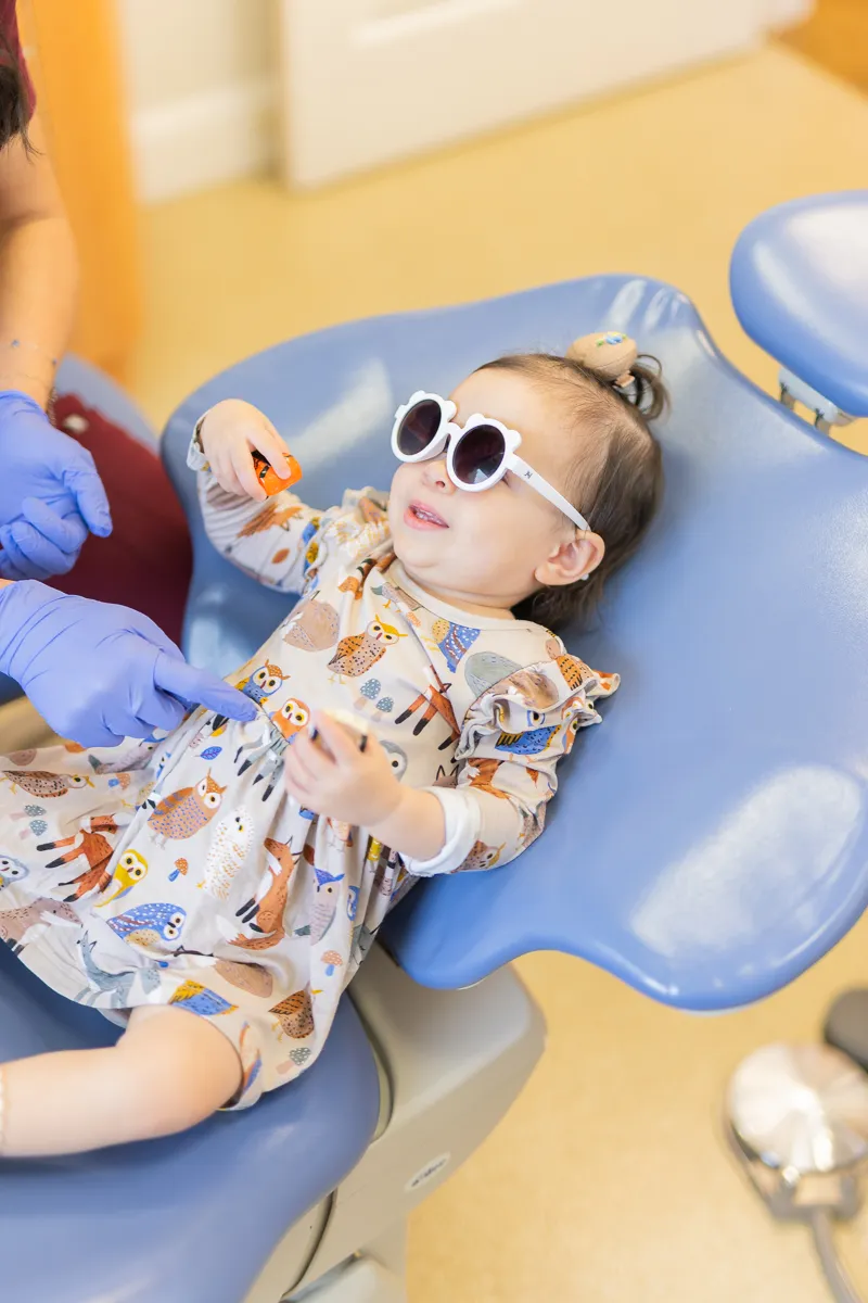 A young patient wearing sunglasses in the dental chair