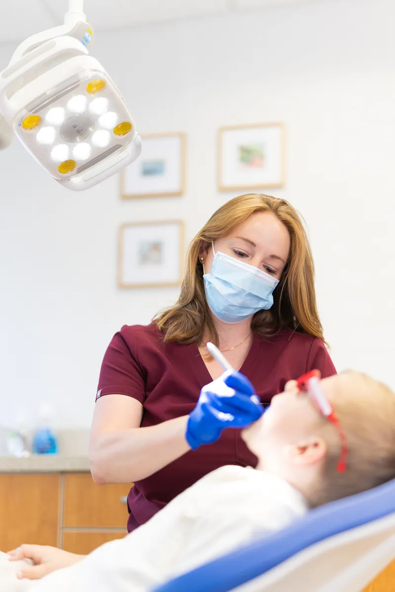 A dentist caring for a young child in the dental chair