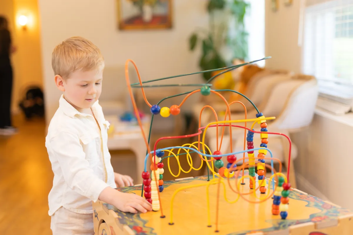 A child playing with the colorful bead maze toy in the waiting room