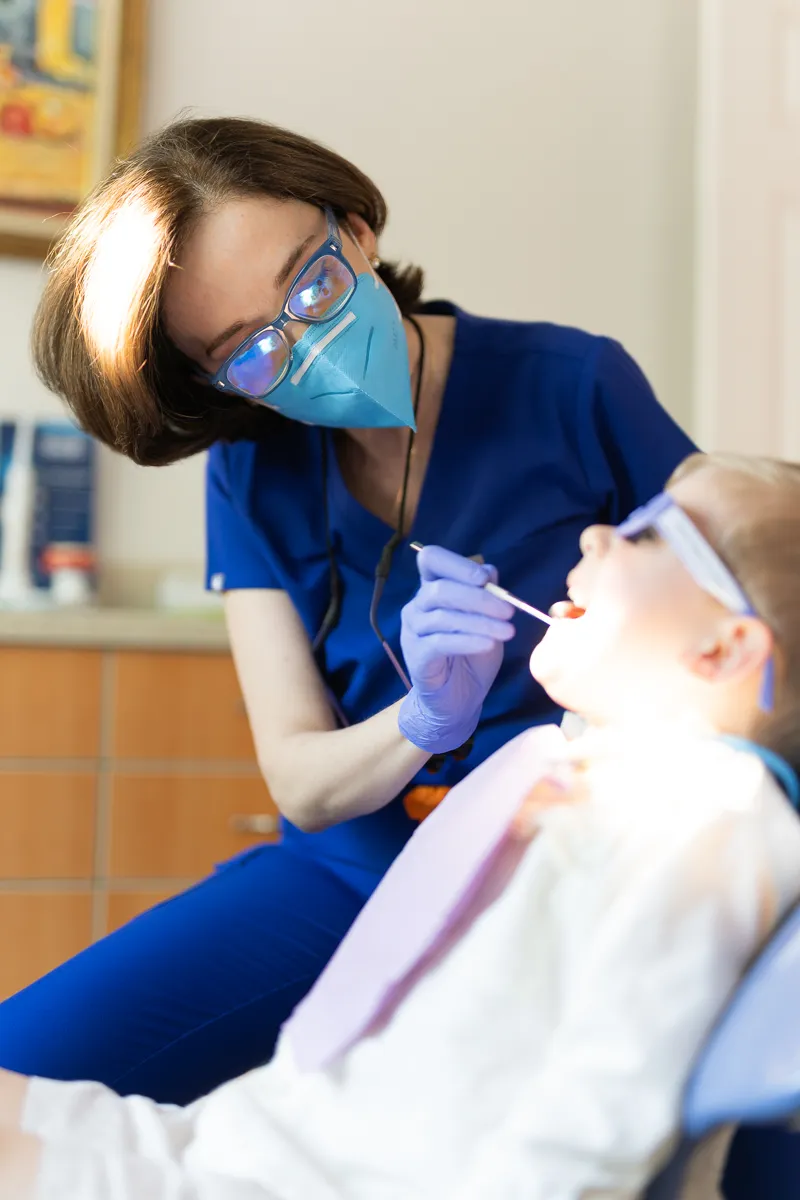 A pediatric dental hygienist examining a young patient at Darien Pediatric Dentistry