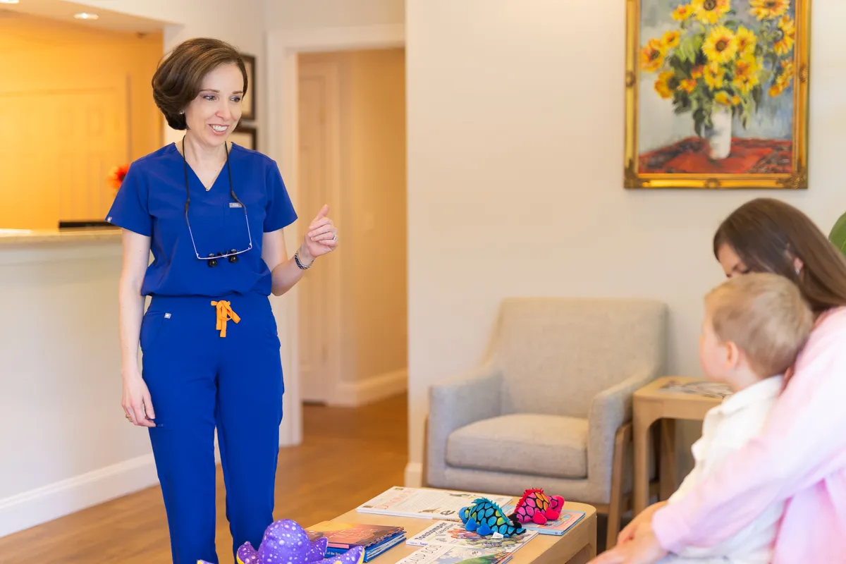 A dental team member welcoming a child in the waiting room