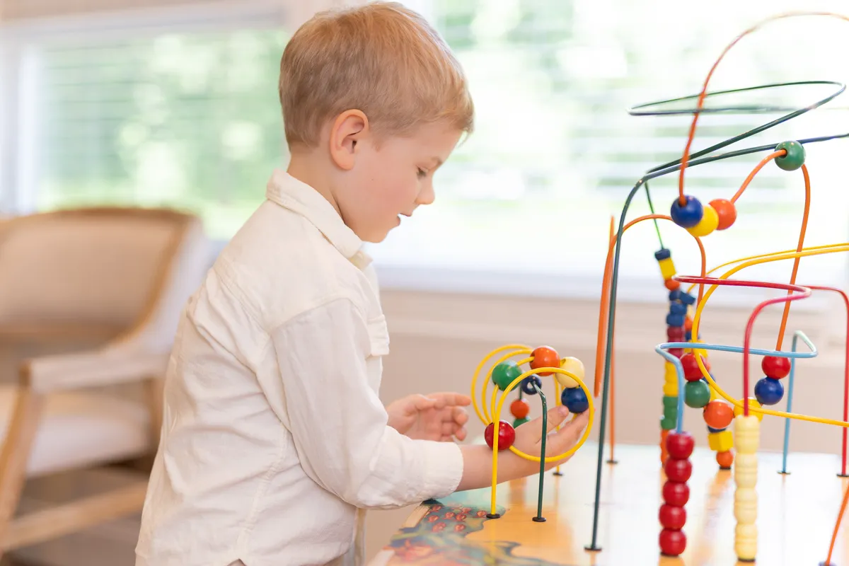 A child playing with the bead-maze toy in the Darien Pediatric Dentistry waiting room